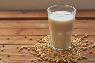 Glass cup with soy milk on wooden table. Vegan food concept.