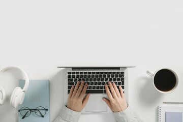 Online learning education, freelance and office work flat lay. Headphones, laptop keyboard with womans hands, glasses and coffee cup on white background.