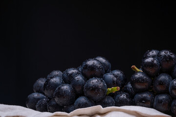 large grapes on a cloth on a black background.
A variety called Nagano Purple