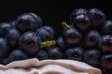 large grapes on a cloth on a black background.
A variety called Nagano Purple