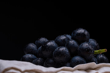 large grapes on a cloth on a black background.
A variety called Nagano Purple