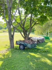 Trailer filled with cut wood in a yard. Pile of firewood.