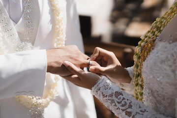 Bride and groom exchange rings at the wedding, the Bride Putting the Ring on the Groom's Hand