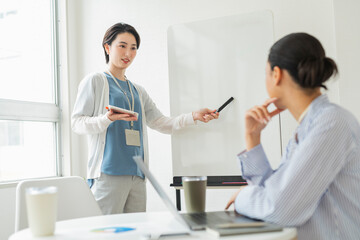 Fototapeta premium オフィスでプレゼンをする2人の女性
