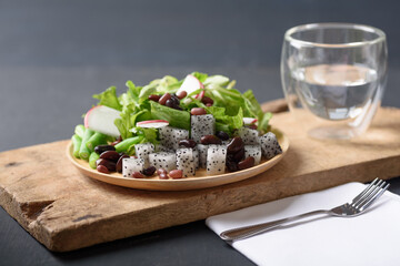 Fresh fruit and vegetable salad with kidney bean, azuki bean, green bean, dragon fruit, radish, lettuce and corn salad. Concepts of healthy food, vegetarian and lifestyle trends.