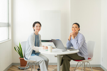 Obraz premium オフィスでミーティングをする2人の女性