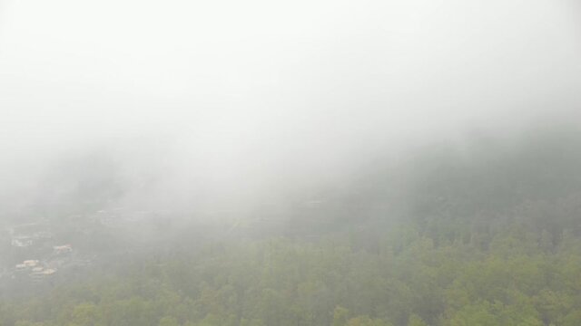 Aerial drone footage flying upward into the clouds in El Qammouaa Forest, Akkar Lebanon