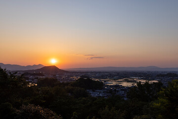奈良の盆地に沈む夕陽と輝く水田