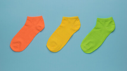 Red, yellow and green short socks on a blue background.