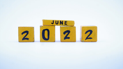 Wooden block calendar for June 2022. Yellow on a white background