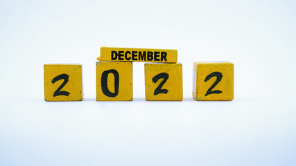 Wooden block calendar for December 2022. Yellow on a white background