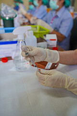 Medical team  in full uniform holding syringe taking covid 19 corona virus vaccine from vial bottle preparing for injection,Vaccination and immunization against covid-19,Coronavirus immunization.