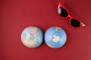 Red eyewear sunglass world atlas globe map north south pole on red paper background