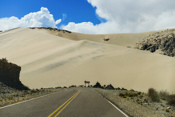 Fototapeta na wymiar Sand dunes towering above the scenic Cuesta de Randolfo stretch of the Provincial Route 43, on the way to Antofagasta de la Sierra, Catamarca, Argentina