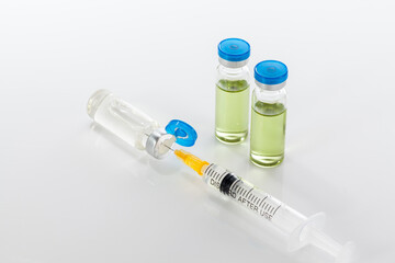 Vaccine bottles and syringe on white backround.