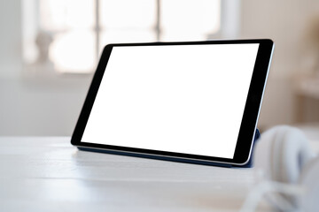 White working table with blank screen digital tablet