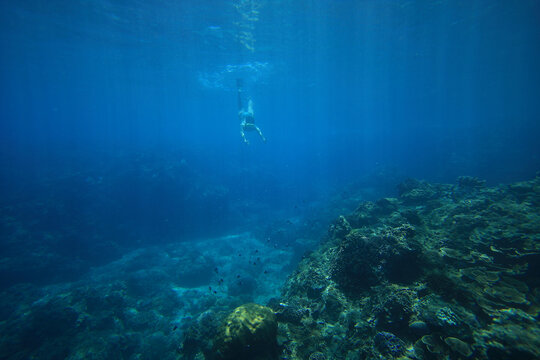 woman diving underwater in the clear Pacific ocean in Taiwan