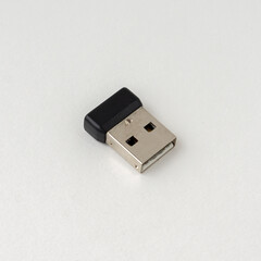 Wireless mouse dongle isolated on white background.