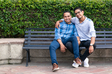 latin couple gay men sitting on a bench, gay concept