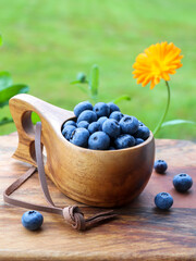 Blueberries in a wooden cup on a outdoor table