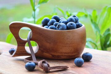 Blueberries in a wooden cup on a outdoor table