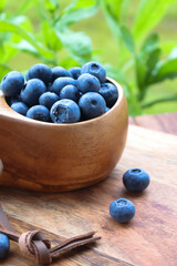 Blueberries in a wooden cup on a outdoor table