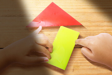 Human hand folding a colored paper