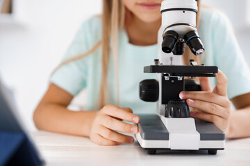 Fototapeta na wymiar Close up photo of little girl using microscope
