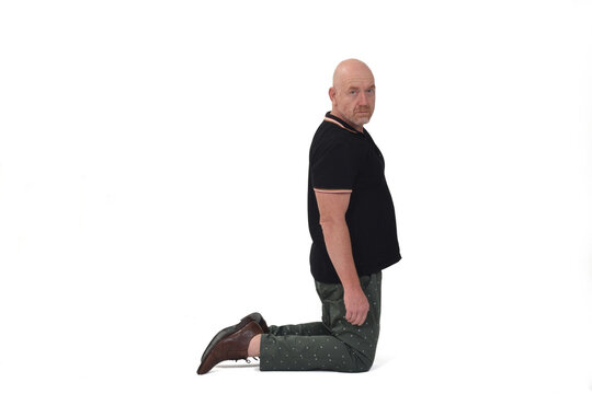 Man Kneeling On White Background Looking At Camera