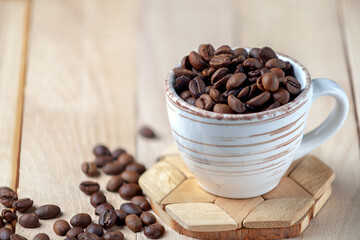 Roasted coffee beans in a ceramic cup. Symbolic image. Copy space.