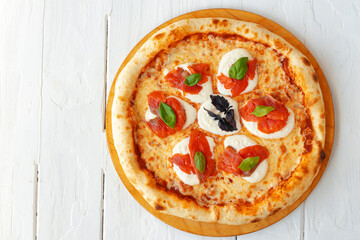 Hot pizza Margherita on white wooden table