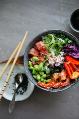 Bowl with rice, shrimp, salted salmon, edamame beans, red cabbage and fresh cucumbers. Healthy food in Asian style.