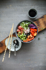 Bowl with rice, shrimp, salted salmon, edamame beans, red cabbage and fresh cucumbers. Healthy food in Asian style.