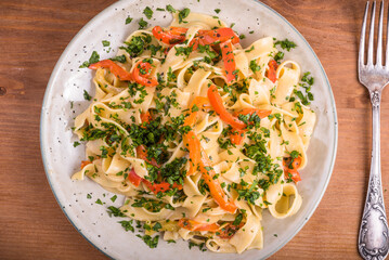 Classic Italian vegetarian pasta with creamy bell pepper sauce - serving in a plate with parsley, close-up, top view