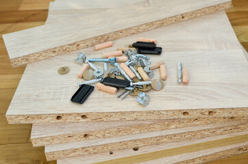 Chipboard sheets and components for furniture assembly close-up. Manufacturing and self-assembly of furniture at home. parts are spread out on floor.