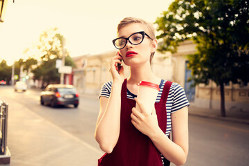 pretty woman with glasses on the street talking on the phone in summer