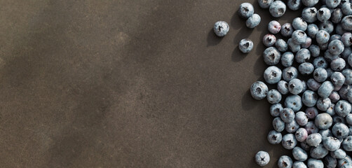 Blueberries ripe and tasty on a black background. Top view, rustic style.