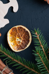 Christmas background, celebration, New Year's party concept. Beautiful decorations and decorations for food. Christmas tree branches with dried oranges and cinnamon on a dark background