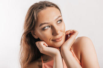 Fototapeta premium Beautiful young girl smiling and posing looking at the camera on a white isolated background. Positive brunette woman. Kind look. Beauty face