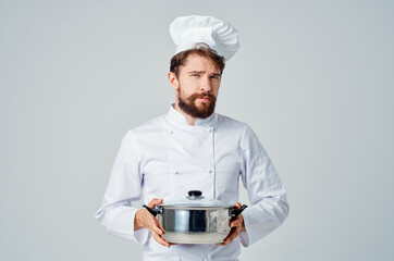 a man in a chef's uniform with a pan in his hands cooking food service