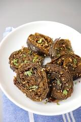 Fototapeta na wymiar Alu Vadi, Patra, paatra, colocasia leaves roll, Patrode is a popular Indian healthy steamed snack. Garnished with sesame and mustard seeds. copy space.