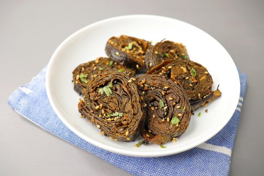 Alu Vadi, Patra, paatra, colocasia leaves roll, Patrode is a popular Indian healthy steamed snack. Garnished with sesame and mustard seeds. copy space.