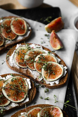 toast with figs, cream cheese and thyme on a black plate on the breakfast table, healthy vegetarian snack or dish, white background, close up, flat lay