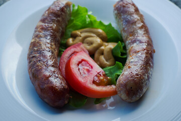 Traditional Istrian (Croatian) sausages with truffle grilled on barbeque and served with fresh farmer's tomato and homemade mustard