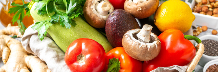 Fasting mimicking diet food. FMD to improve health and lose weight. A mix of vegetables, nuts, herbs, seeds and mushrooms on a light gray background closeup. Banner