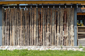 Eco fence made of tree logs. Eco shop wall