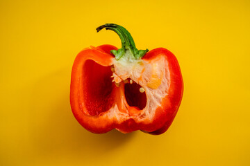 Half red bell pepper close-up on a yellow background. Top view.