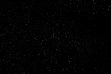 Falling snow on a black background. small particles with bright dots starry sky. Сhaotic white bokeh. light spots texture. abstract.