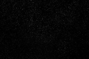 Falling snow on a black background. small particles with bright dots starry sky. Сhaotic white bokeh. light spots texture. abstract.