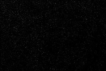 Falling snow on a black background. small particles with bright dots starry sky. Сhaotic white bokeh. light spots texture. abstract.